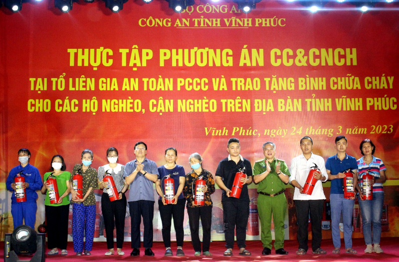 Thứ trưởng Nguyễn Văn Long và Chủ tịch UBND tỉnh Lê Duy Thành trao tặng bình chữa cháy cho đại diện gia đình hộ nghèo, hộ cận nghèo trên địa bàn tỉnh